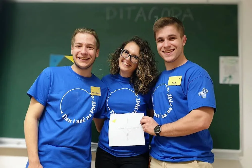 Borna and two friends in front of a blackboard covered in maths at the Faculty's open house.